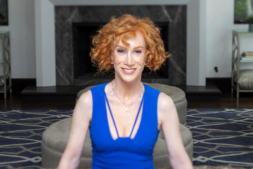 A woman with short red hair sitting in a blue dress