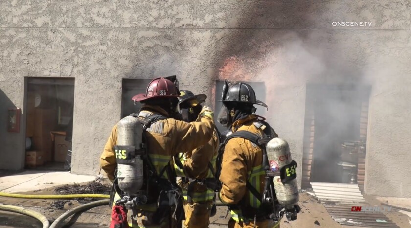 Firefighters discuss strategy while battling a blaze Thursday afternoon at Storage Outlet in Chula Vista.