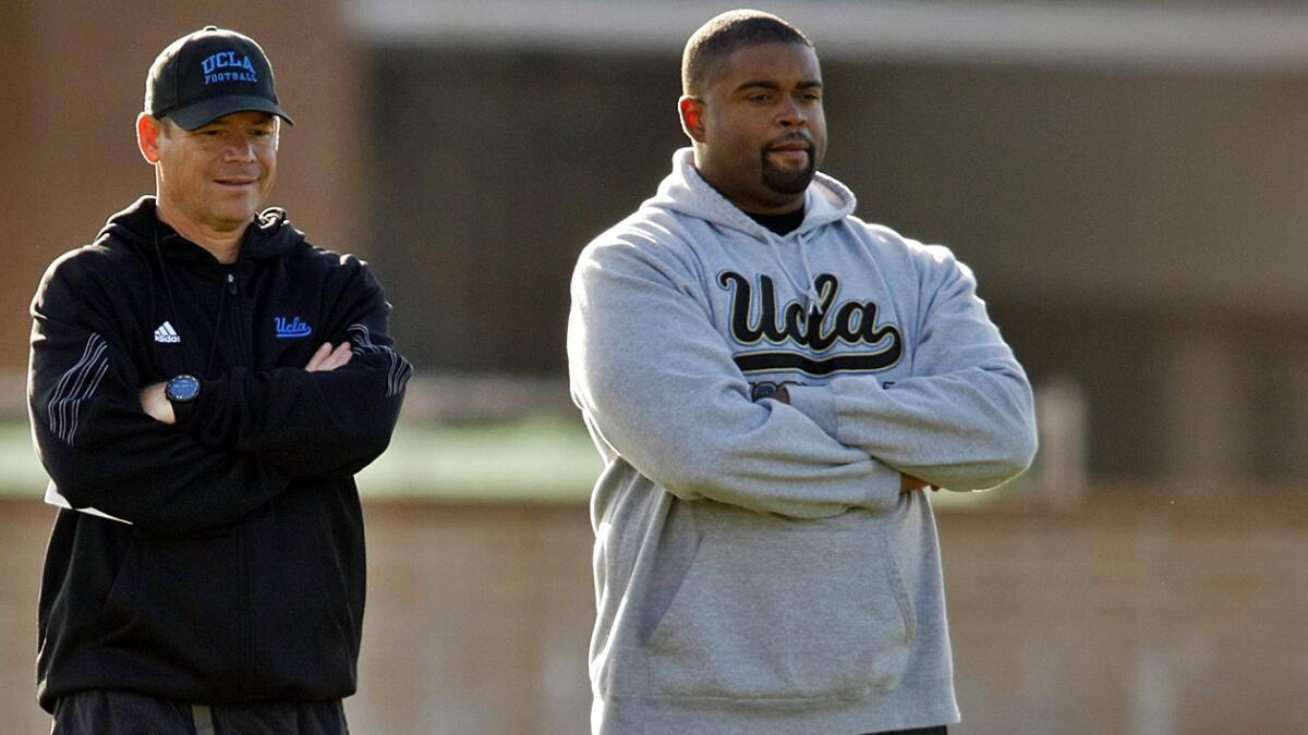 UCLA offensive line coach Adrian Klemm, right, with Coach Jim Mora during a spring practice session in April 2014.