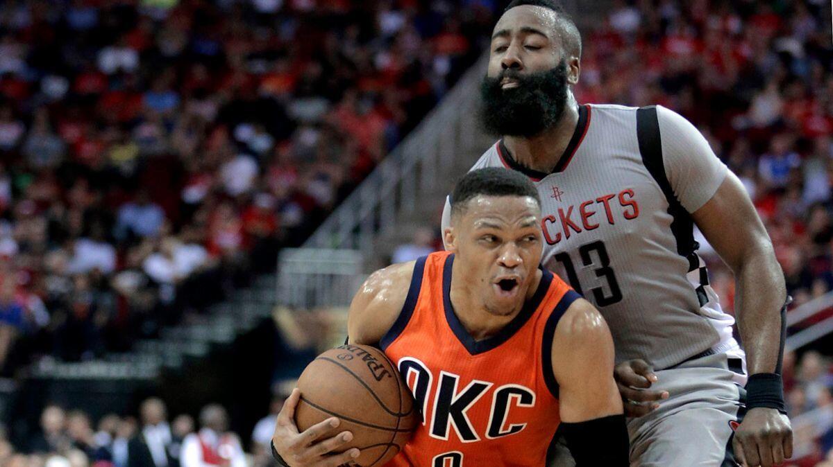 Oklahoma City Thunder's Russell Westbrook (0) is fouled as he drives around Houston Rockets' James Harden (13) during the first half on March 26.