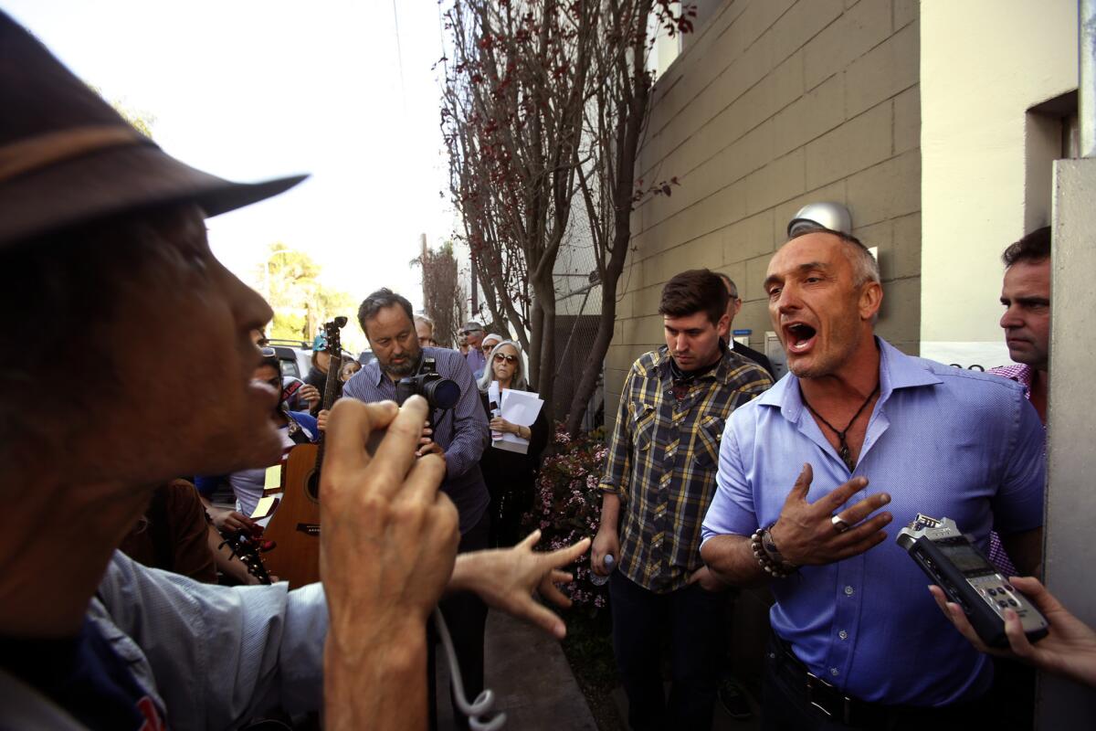 Mark Lipman, with People Organized for Westside Renewel, left, argues with Sebastian de Kleer, owner of Globe Homes and Condos, at a protest in Venice on Wednesday. The firm had many of its L.A. Airbnb listings removed this week.