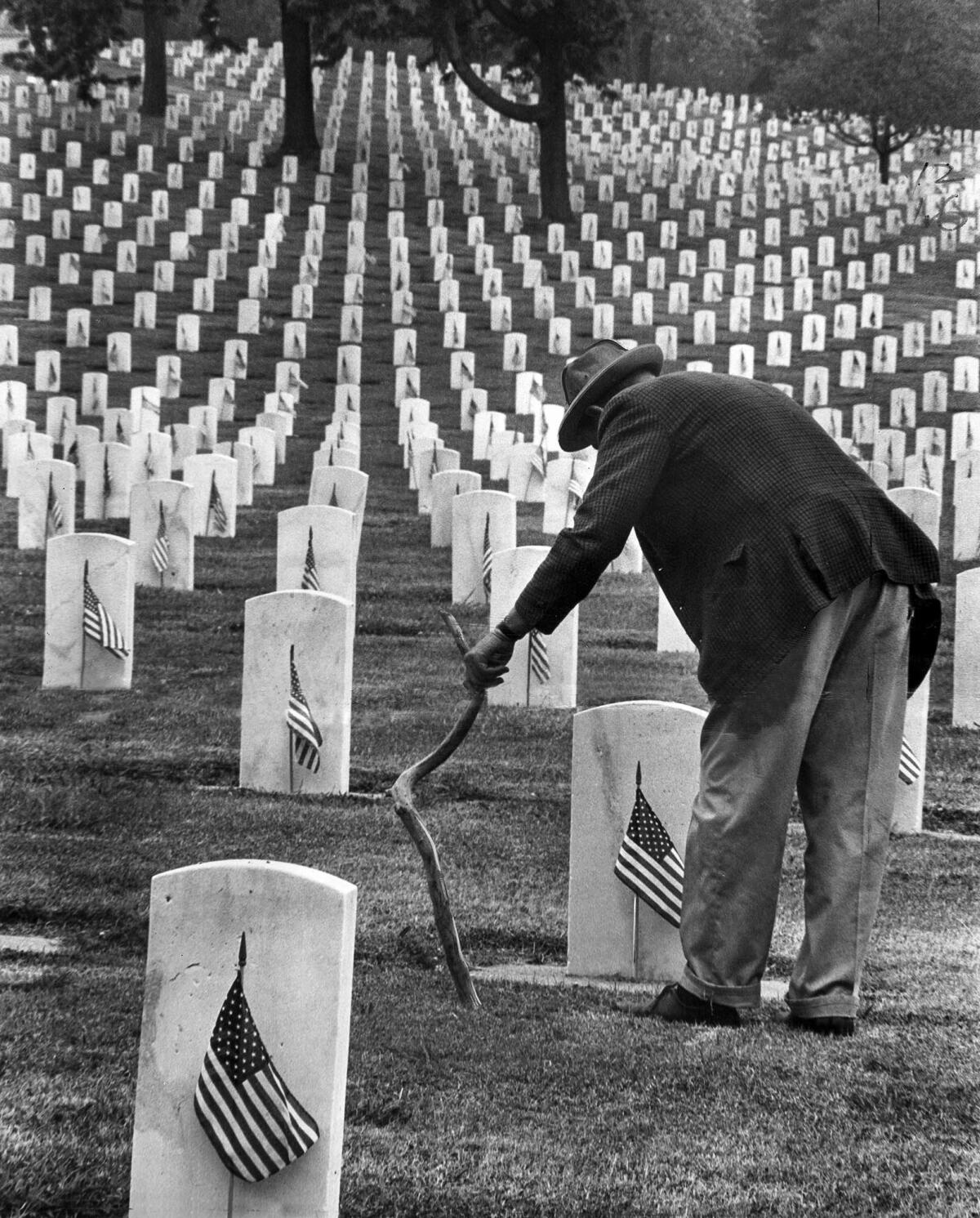 May 29, 1967: Veteran Charles Billstron, 47, leans on his walking stick as he examines headstone at Sawtelle Veterans Cemetery. Billstrom, a former Air Force sergeant, came look for the grave of a friend.