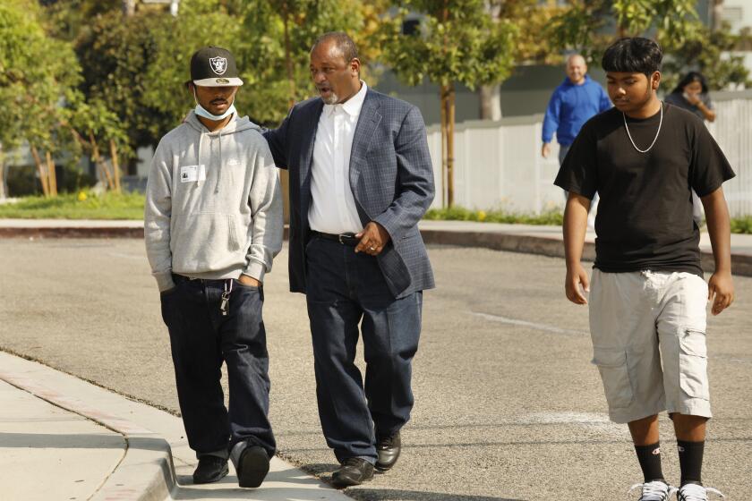 Long Beach, California-Sept 29, 2021- Rafeul Chowdhury, right, community activist Najee Ali, center, and Shahreaf Chodhury, age 16, right, arrive at a press conference on Sept. 29, 2021, heading back to Long Beach Memorial Care Hospital. Rafeul Chowdhury, age 20, is the partner of Mona Rodriguez who is on life support after a Long Beach Public safety officer shot her as she sat in the passenger seat of a car unarmed. Rodriguez, the 18-year-old victim is not expected to survive. Shahreaf Chodhury, age 16, left, and Rafeul Chowdhury, 20, were also in the car with Rodriguez when the officer fired into the car. (Carolyn Cole / Los Angeles Times)