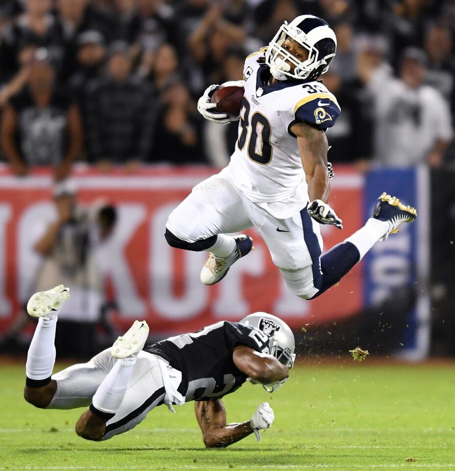 Rams running back Todd Gurley is upended by Raiders cornerback Melvin Rashaan after picking up yards in the 3rd quarter at the Oakland Coliseum Monday night.