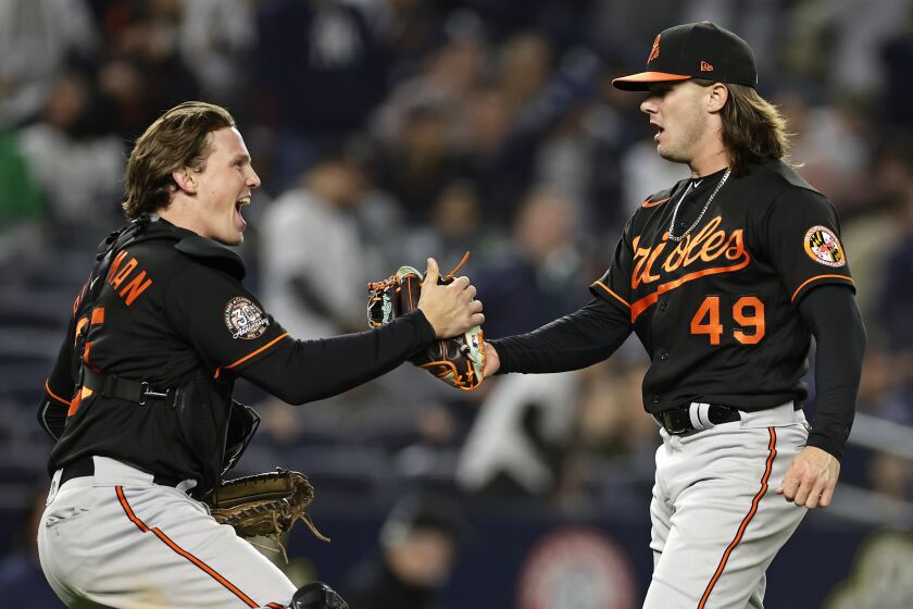 Baltimore Orioles pitcher DL Hall (49) celebrates with Adley Rutschman after the team's 2-1 win in a baseball game against the New York Yankees on Friday, Sept. 30, 2022, in New York. (AP Photo/Adam Hunger)