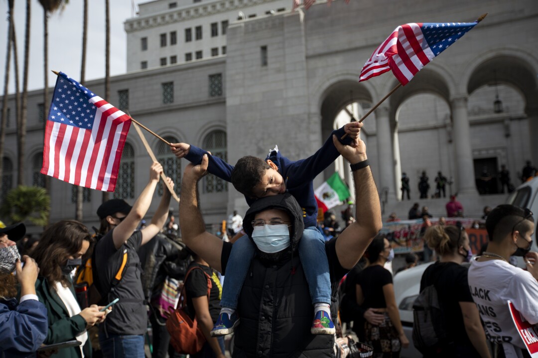 Sham Taha, 35, holds up son Asset near L.A. City Hall.