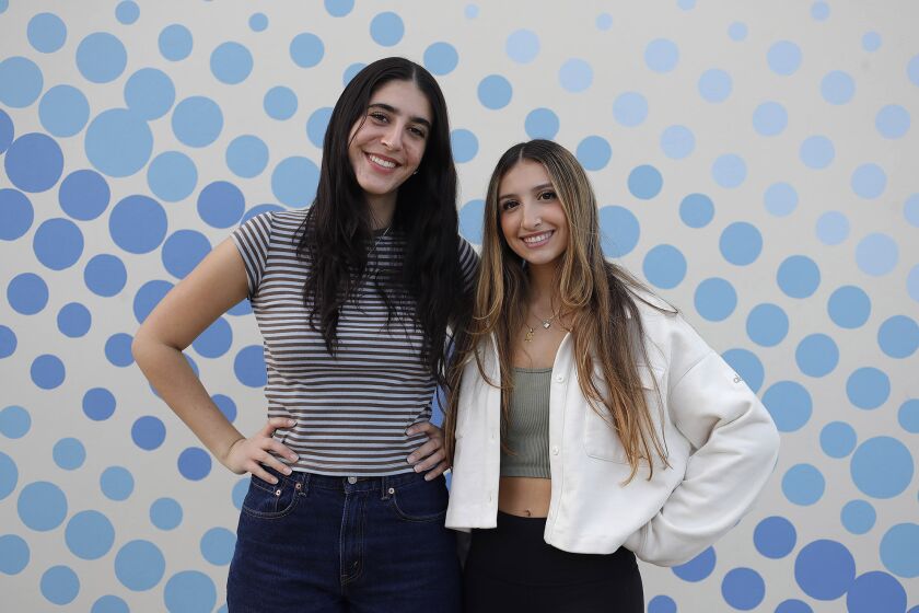 Corona del Mar High School seniors Ella Avital and Yasmeen Kalell, from left, spoke at the Newport-Mesa Unified School District board meeting on Tuesday night, calling on board members to make greater efforts to stock quality menstrual supplies on campus.