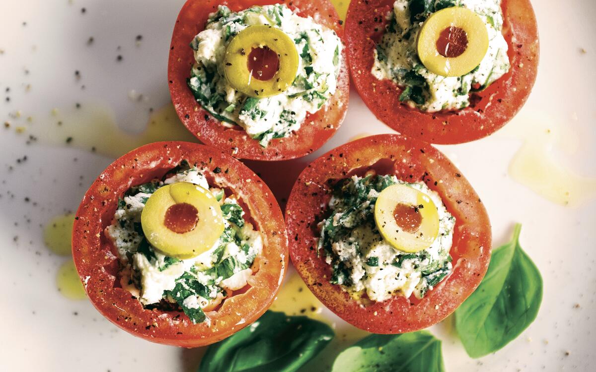 Tomatoes filled with whipped cheese and herbs topped by slices of green olives