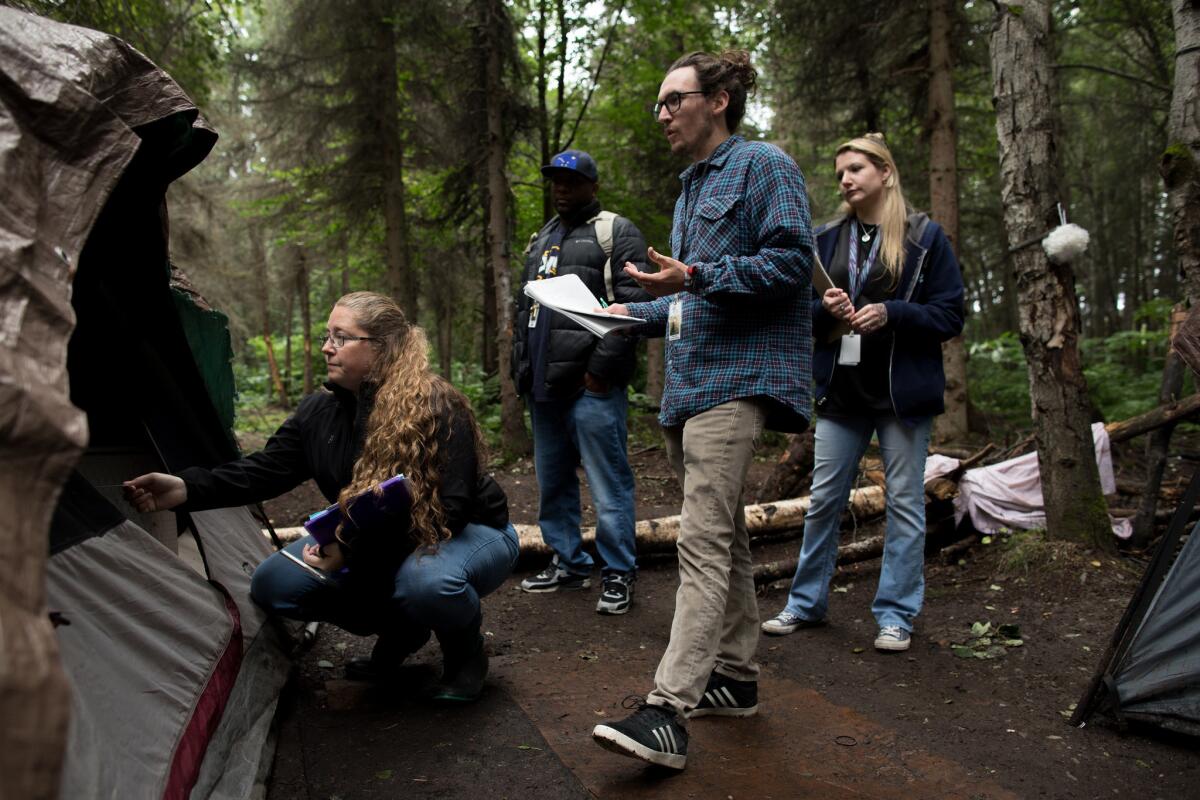 From left, homeless outreach workers Tanya Vandenbos, Sean Sullivan, Chalon Lubin and Tanya Vandenbos check in at a camp where they educate residents about social services opportunities.