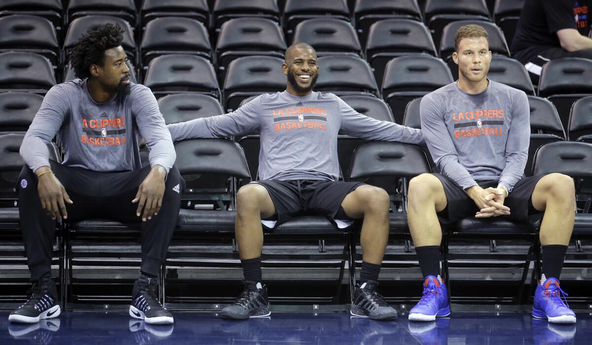 Clippers players, from left, DeAndre Jordan, Chris Paul and Blake Griffin take a breather after doing some running at practice. The team is preparing for Monday's preseason game against the Utah Jazz.