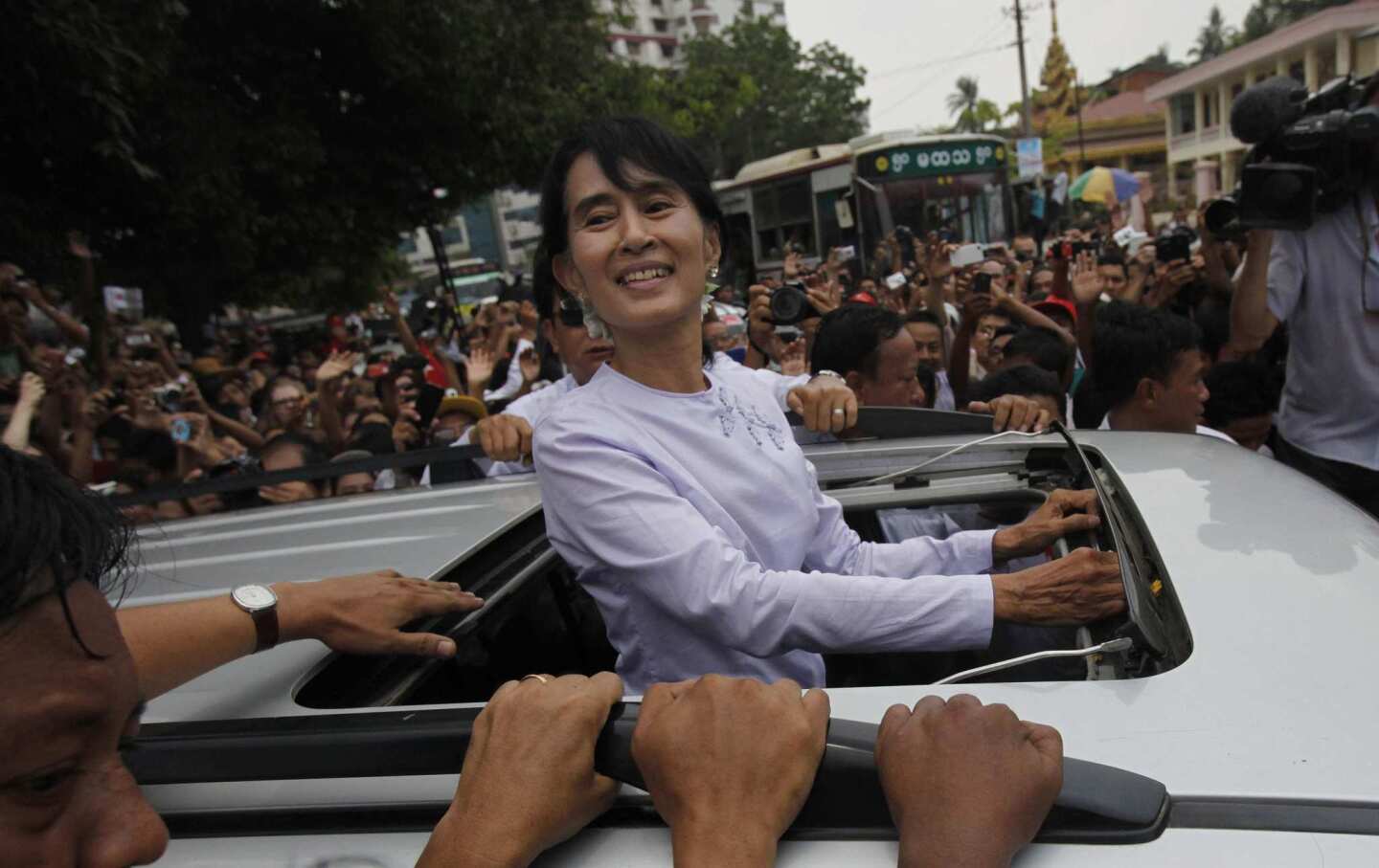 Opposition leader Aung San Suu Kyi acknowledges supporters from her car as she leaves after a brief visit to the headquarters of her National League for Democracy Party in Yangon, Myanmar. Suu Kyi said she hopes her victory in a landmark election will mark the beginning of a new era for Myanmar.
