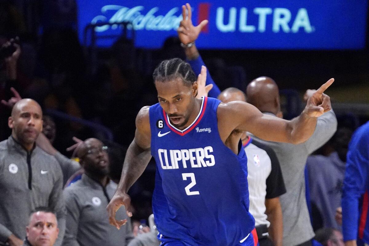 Kawhi Leonard points to a teammate after scoring during the Clippers' season opener against the Lakers.