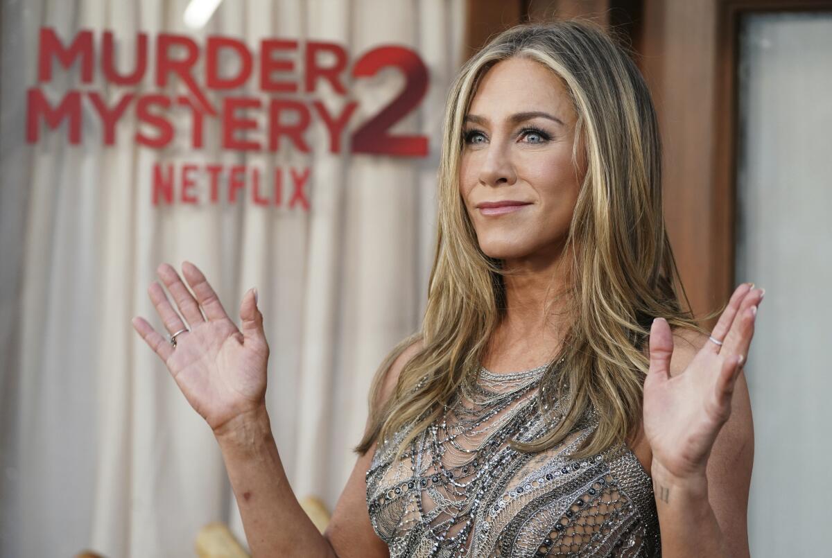 Jennifer Aniston holds up both hands at shoulder-height at the "Murder Mystery 2" premiere