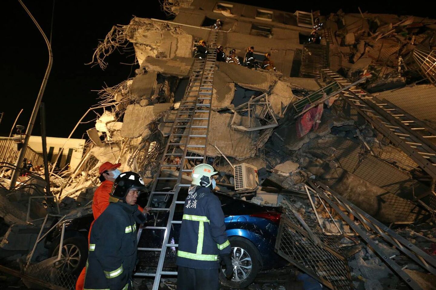Rescue personnel search through debris at the site of a collapsed building in the southern Taiwanese city of Tainan following a 6.4 magnitude quake early Feb. 6.