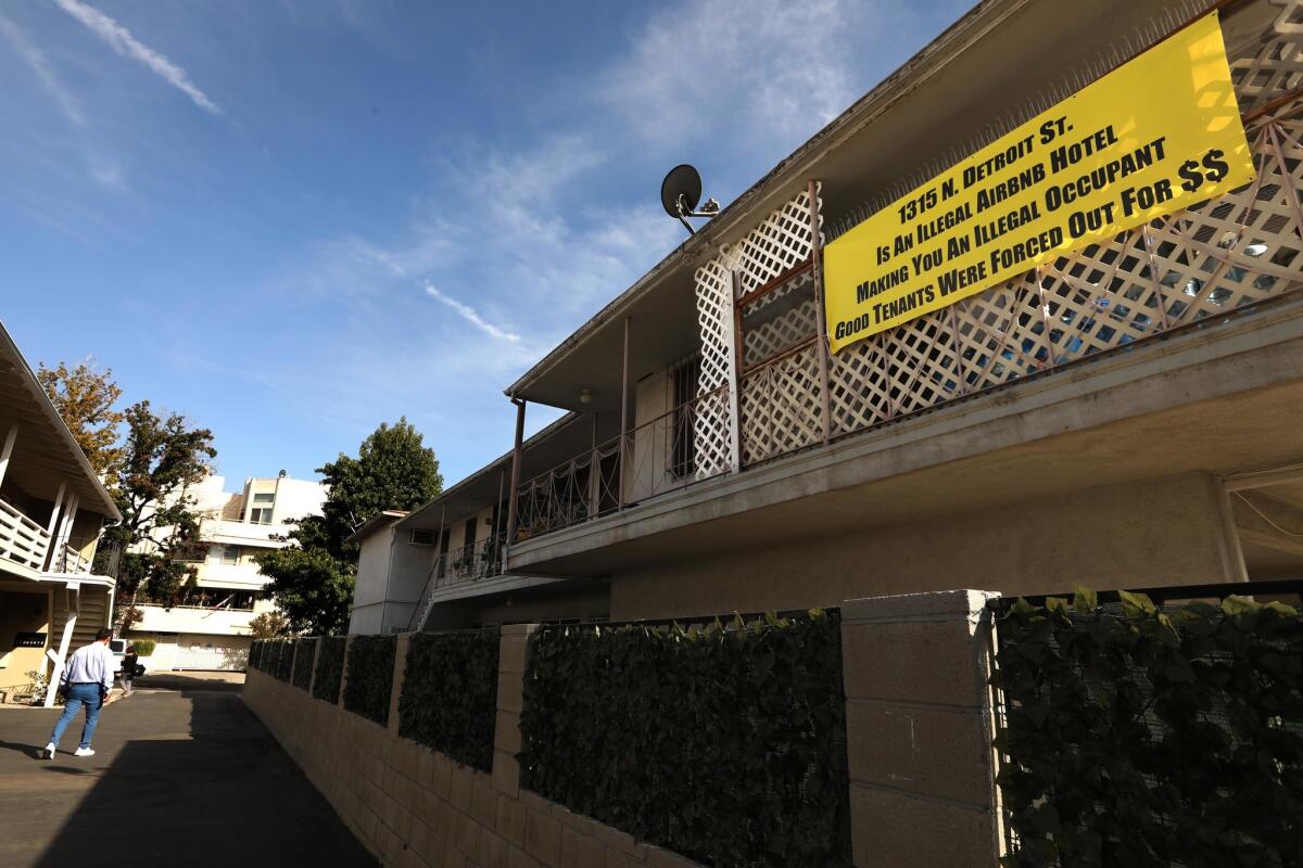 A sign posted by a neighbor asserts that the apartments at 1315 N. Detroit Street are being used illegally as Airbnb rentals. Housing department officials say they are investigating complaints about short-term rentals at the site.