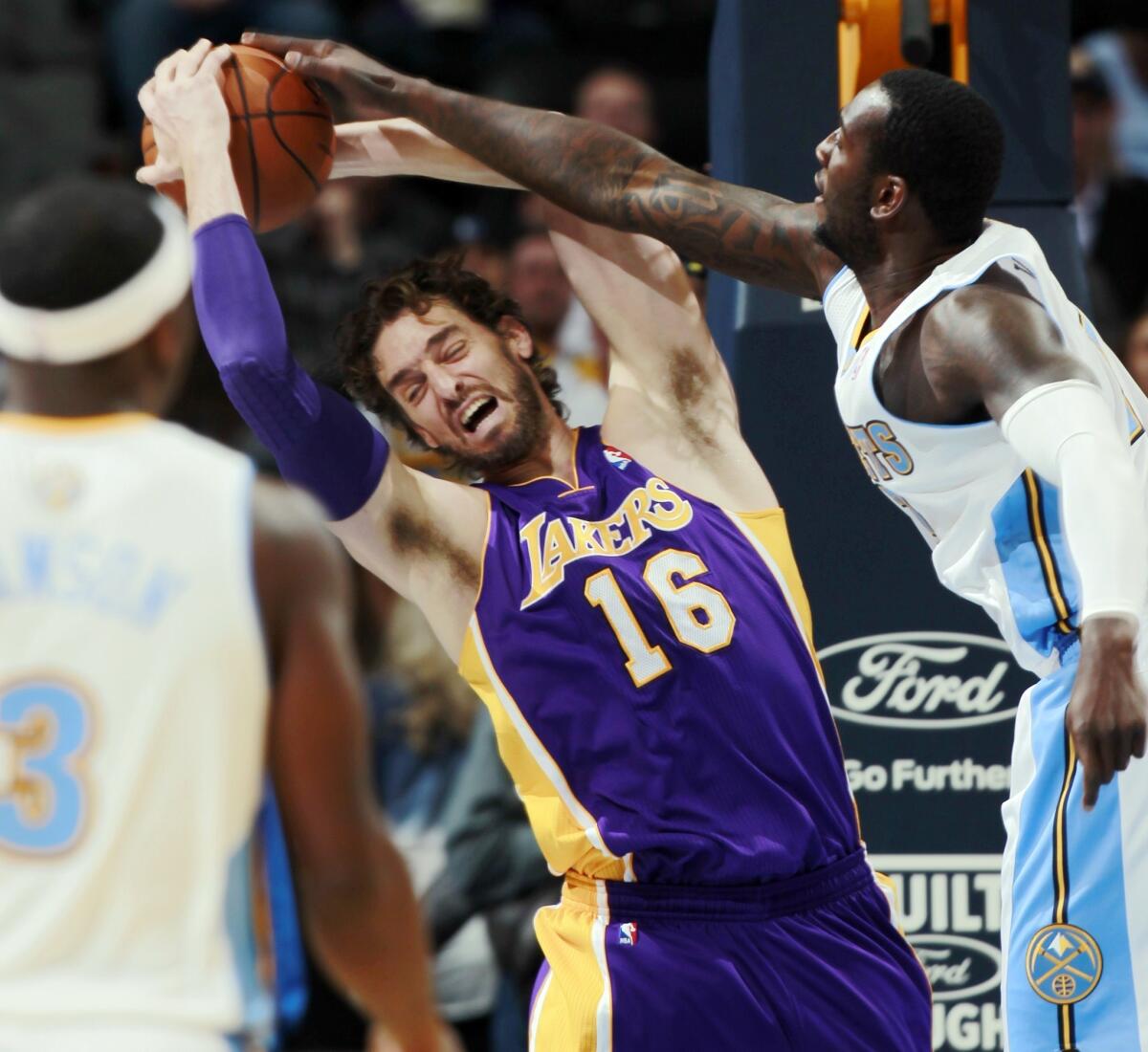 Lakers power forward Pau Gasol pulls a rebound away from Nuggets forward Jordan Hamilton in the first quarter Wednesday night in Denver.