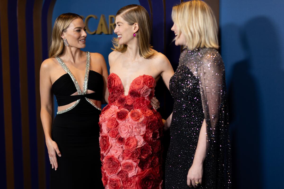 Margot Robbie, Rosamund Pike and director Emerald Fennell, from left, on the red carpet 
