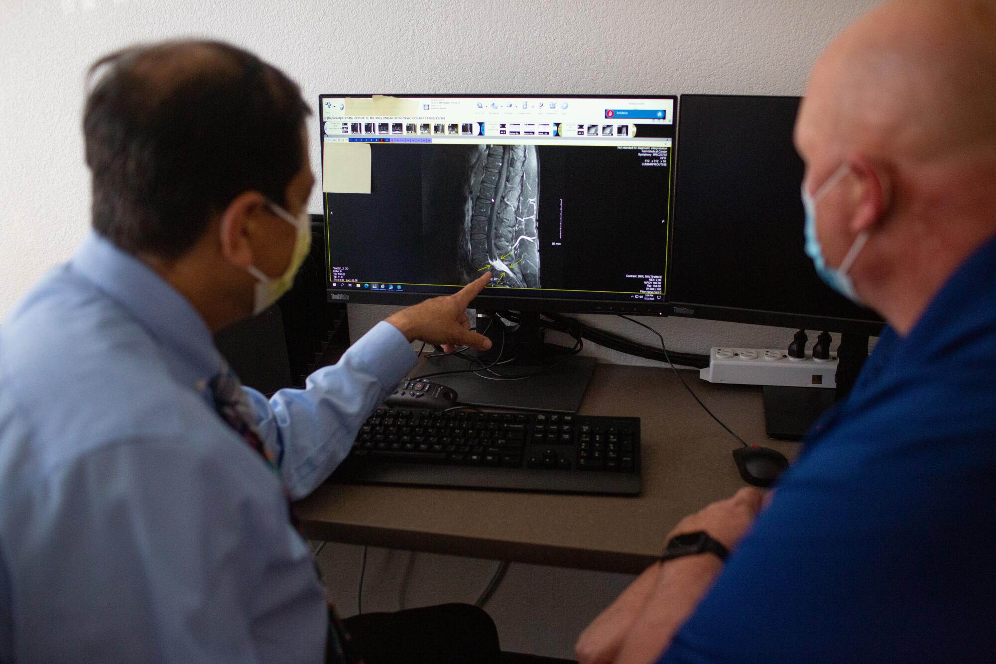 A physician looks over MRI images of a patient's spine that has been attacked by Valley fever.