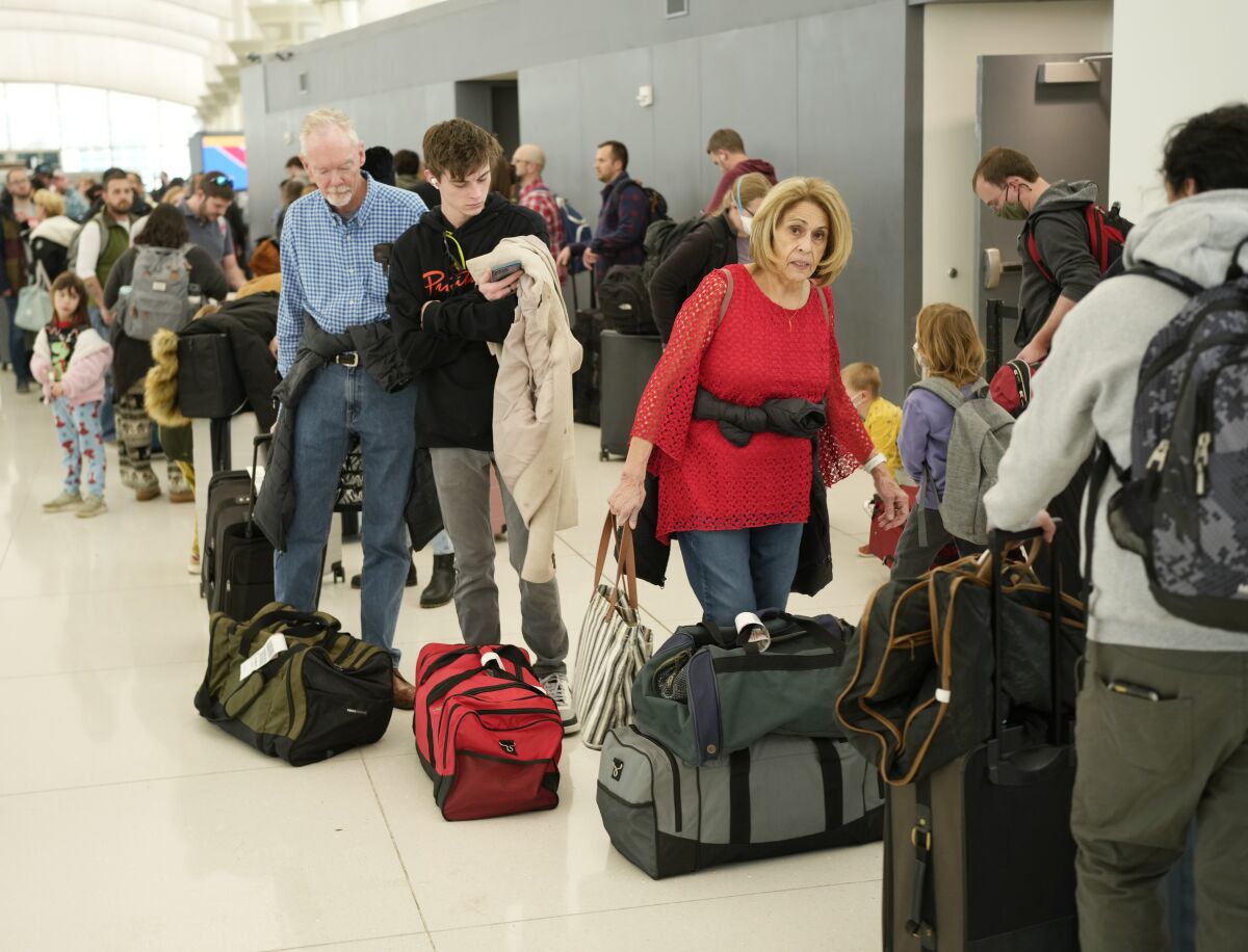 FILE - Travelers wade through the line to drop off bags at the Southwest Airlines check-in counter at Denver International Airport, Dec. 27, 2022, in Denver. Senators who want to impose tougher penalties when U.S. airlines strand or delay passengers say they finally might be able to turn their ideas into law because of outrage over debacles like the one at Southwest Airlines in December 2022. (AP Photo/David Zalubowski, File)