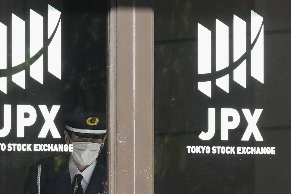 A security guard stands guard at the entrance of the Tokyo Stock Exchange building Wednesday, Nov. 2, 2022, in Tokyo. Asian shares were mostly higher Wednesday ahead of a decision by the U.S. Federal Reserve on an interest rate increase to curb inflation. (AP Photo/Eugene Hoshiko)