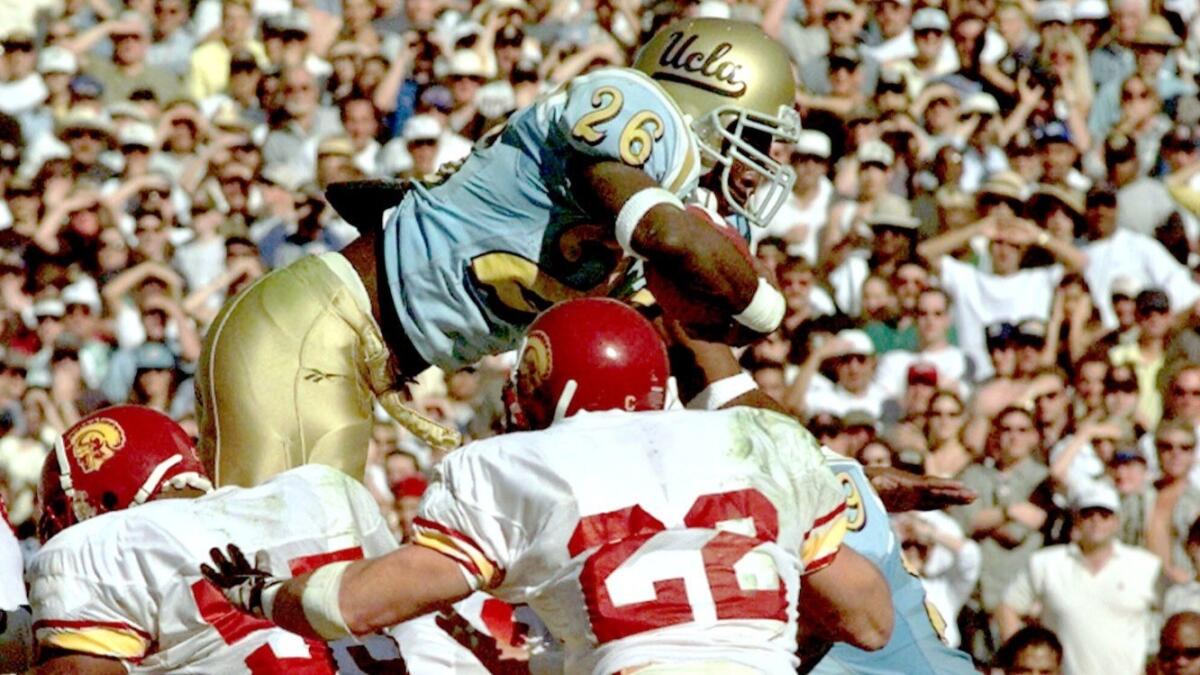 UCLA running back DeShaun Foster dives over USC defenders in the first quarter for one of his four touchdowns in the 1998 UCLA-USC game.