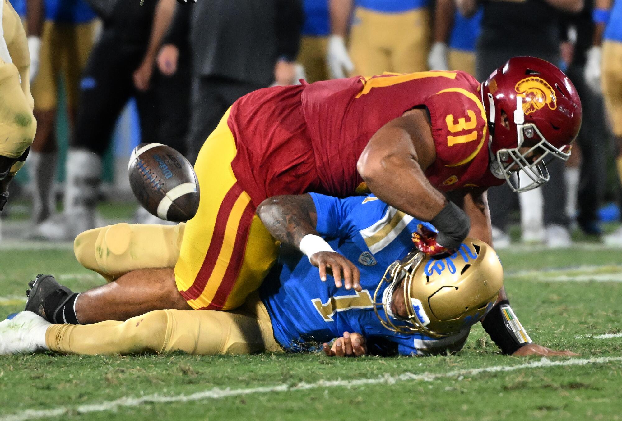 UCLA quarterback Dorian Thompson-Robinson fumbles the ball as he is sacked by USC's Tyrone Taleni in the third quarter.