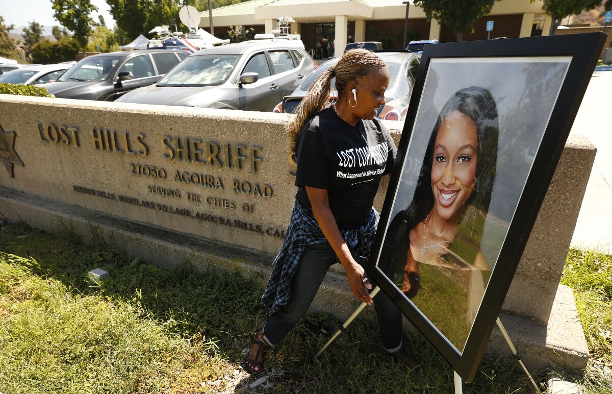 Kim Howard places a photo of Mitrice Richardson at the Lost Hills Sheriff Station