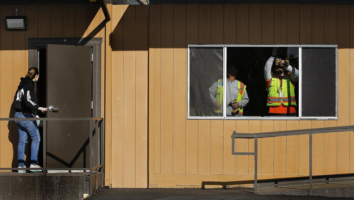 Carpenters install blinds in bungalows at Northridge Middle School.