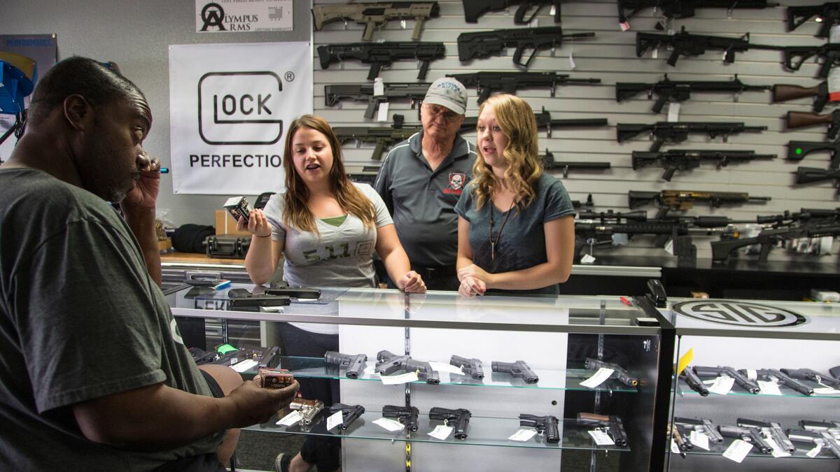 At the Get Loaded gun store in Grand Terrace, store managers Jamie Taflinger, left, and Kendyll Murray show customer Cornell Hall of Highland different types of ammo.