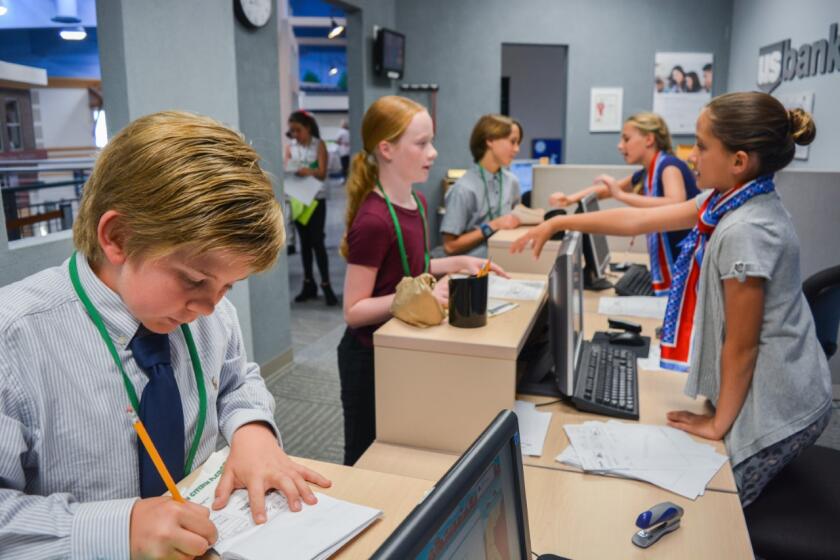 Elementary school students do banking transactions in one of the McGrath Family JA BizTown shops which teach business skills.