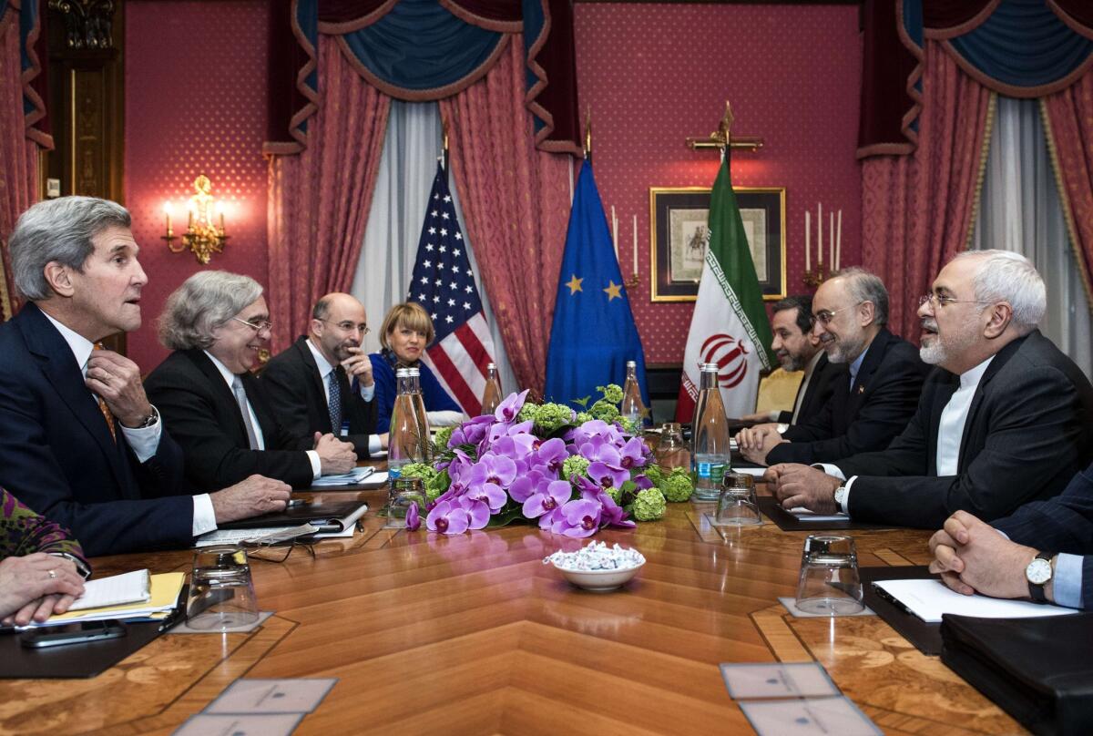 From left, U.S. Secretary of State John F. Kerry and Secretary of Energy Ernest Moniz face, from right, Iranian Foreign Minister Javad Zarif and Ali Akbar Salehi, head of the Iranian Atomic Energy Organization, at a hotel in Lausanne, Switzerland.