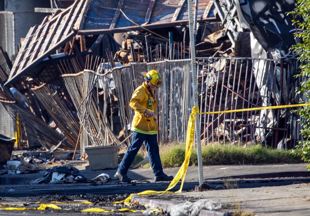 A firefighter surrounded by the ruins of a fire.