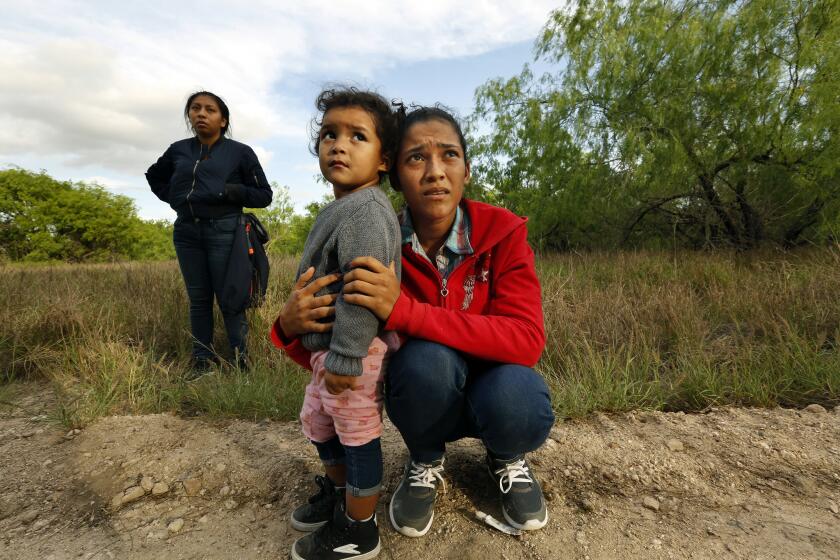 Lirio Funes, 20, holds onto her daughter, Melissa Funes, 2, just after being detained by local officials after crossing the U.S. - Mexico border illegally.