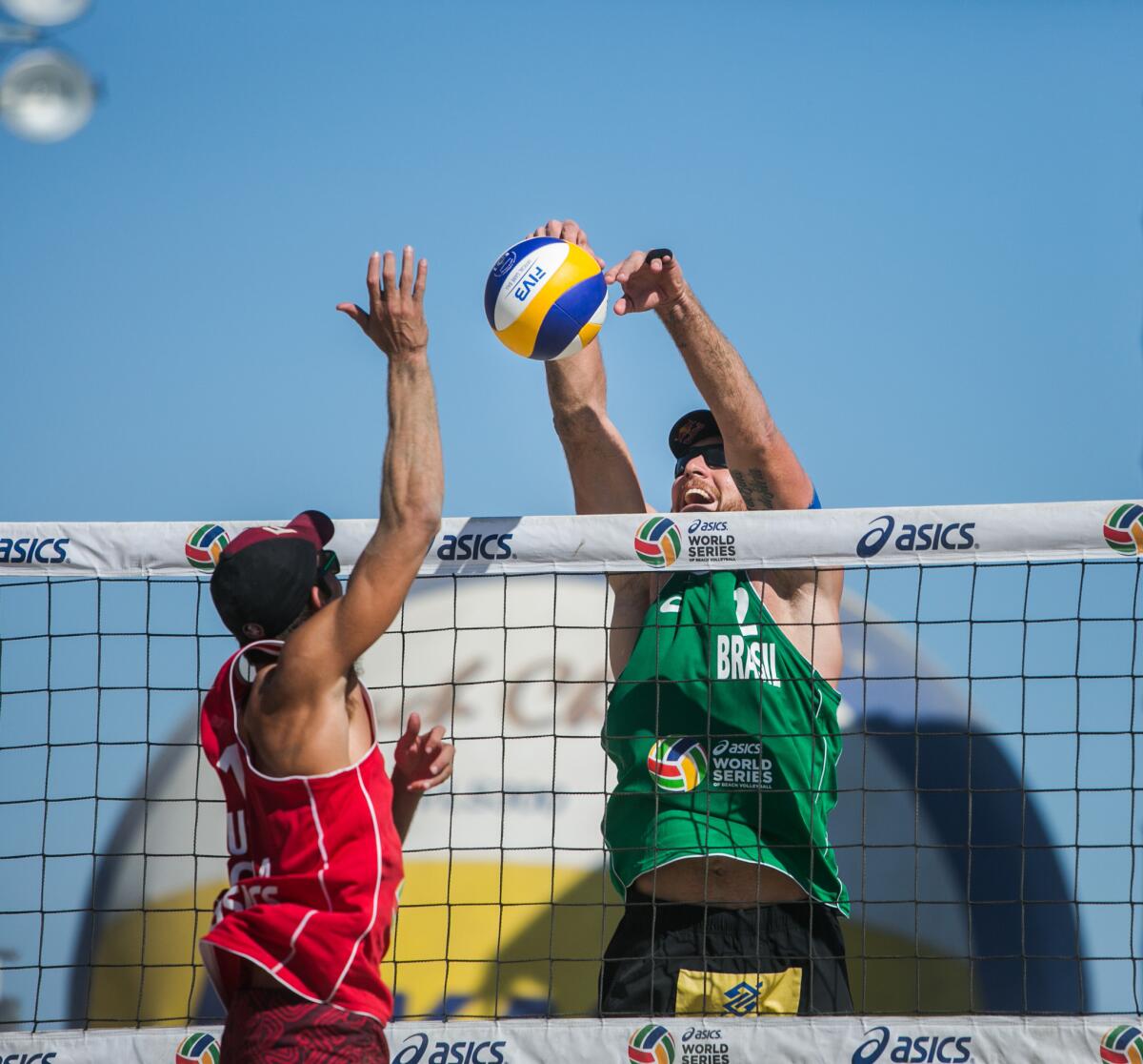 Alison Cerutti blocks a shot by Nick Lucena during the championship match of the World Series of Beach Volleyball.
