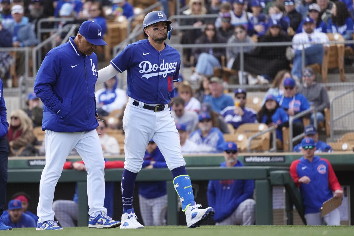 Miguel Rojas talks with Dodgers manager Dave Roberts after cramping up.