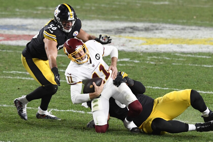 Washington Football Team quarterback Alex Smith (11) is sacked by Pittsburgh Steelers defensive end Stephon Tuitt (91) and Alex Highsmith (56) during the first half of an NFL football game in Pittsburgh, Monday, Dec. 7, 2020. (AP Photo/Barry Reeger)