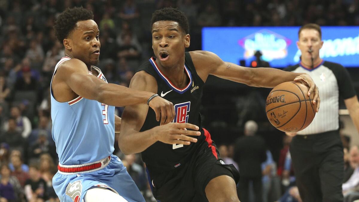 Sacramento Kings guard Yogi Ferrell, left, tries to stop the drive of Clippers guard Shai Gilgeous-Alexander during the first quarter.