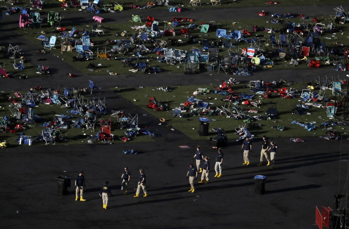 FILE - Investigators work at a festival grounds across the street from the Mandalay Bay Resort and Casino on Oct. 3, 2017, in Las Vegas after a mass shooting. The Nevada Supreme Court cited a state law that shields gun manufacturers from liability unless the weapon malfunctions in a new ruling that says they cannot be held responsible for the deaths in the 2017 mass shooting on the Las Vegas Strip. (AP Photo/Marcio Jose Sanchez, File)