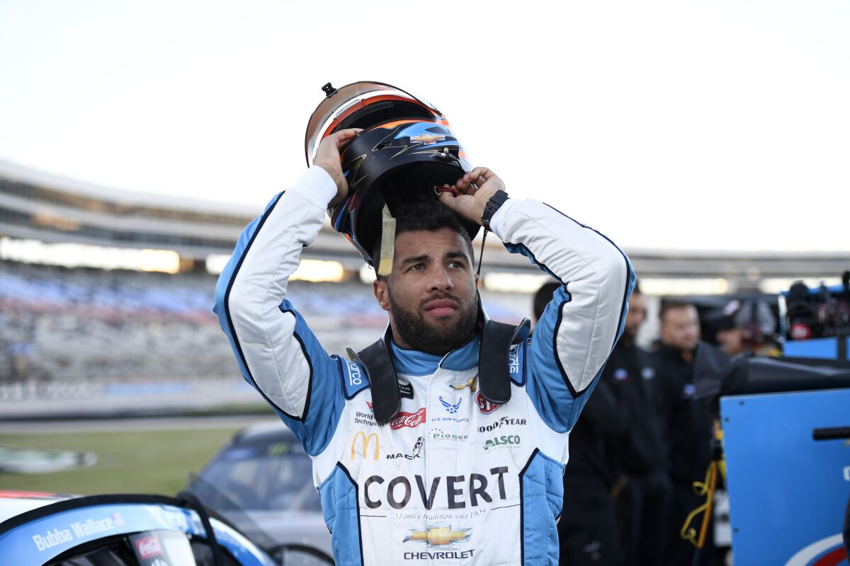FILE - In this Saturday, Nov. 2, 2019, file photo, Bubba Wallace prepares by his car for qualifying for a NASCAR Cup Series auto race at Texas Motor Speedway in Fort Worth, Texas. On Saturday, Nov. 9, 2019, Wallace was fined $50,000 by NASCAR for causing a caution the week before at Texas that affected the race for at least one playoff driver. (AP Photo/Larry Papke, File)