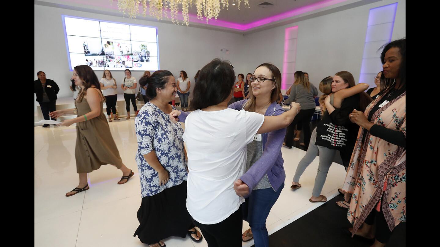 Dozens of mothers share hugs with one another after participating in an affirmation circle during Forever Footprints' annual Nurture to Remember event in Huntington Beach on Tuesday, May 8. The event honored women who have lost their babies.