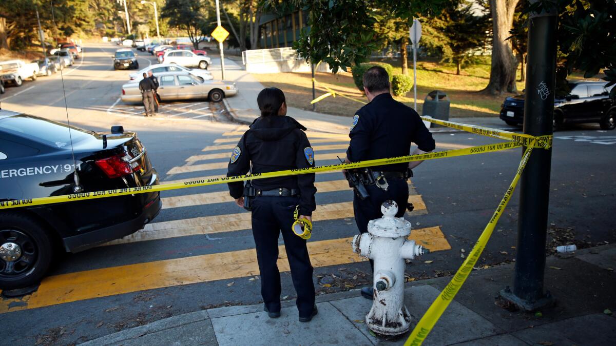 San Francisco police stand at the site of a shooting outside the June Jordan School for Equity in San Francisco on Tuesday.
