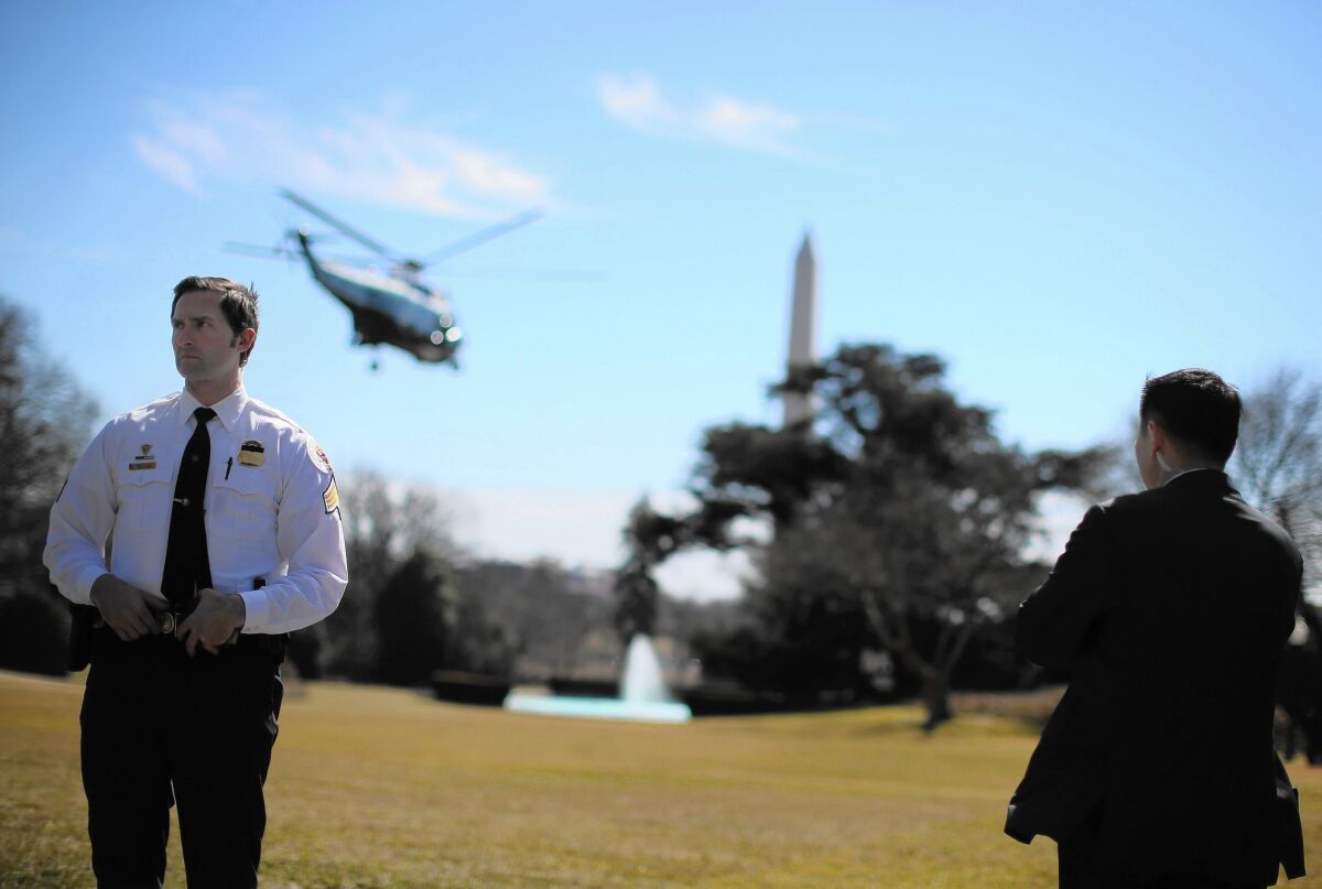 Secret Service members stand watch as President Obama leaves Washington aboard Marine One en route to Los Angeles.