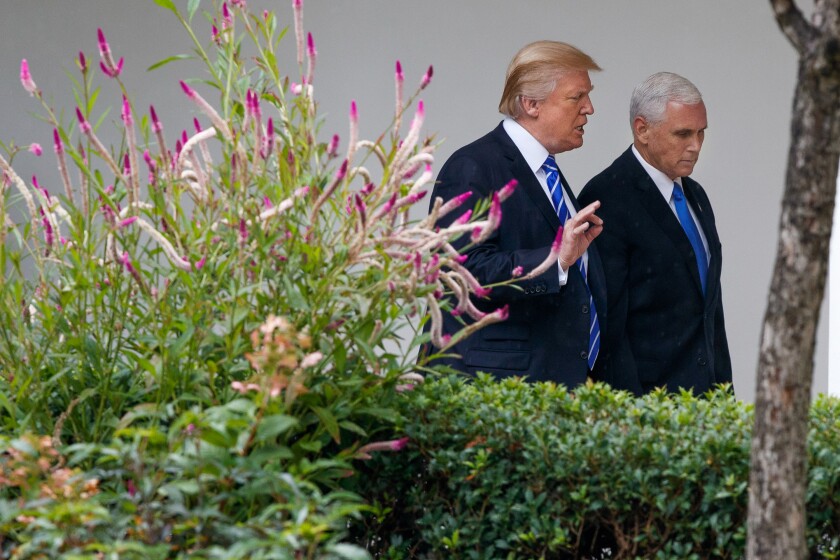 President Trump walks with Vice President Mike Pence in the White House.