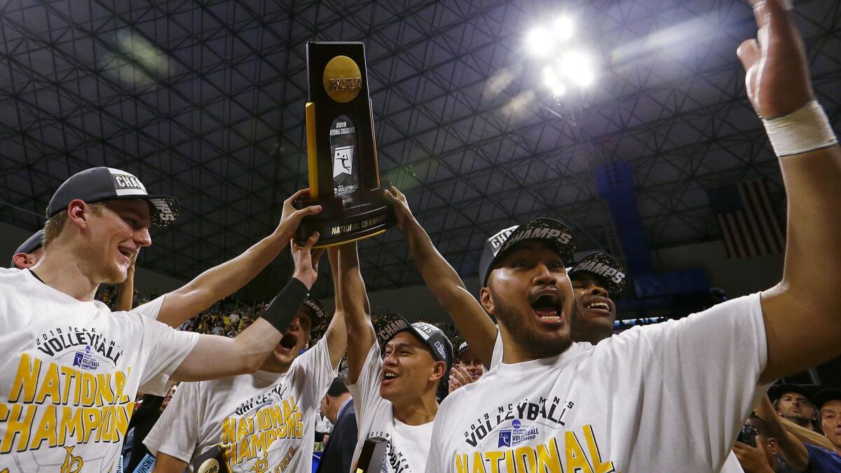 Members of the Long Beach men's volleyball team hoist the NCAA national championship trophy after defeating Hawaii at the Walter Pyramid in Long Beach on May 4, 2019.