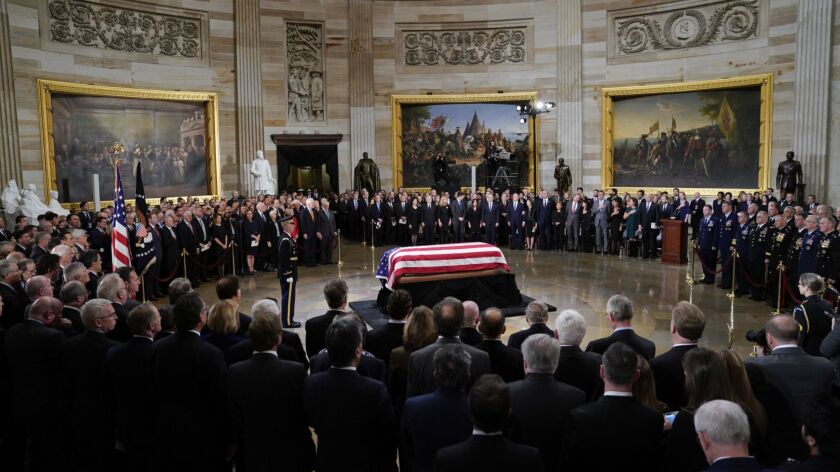 The flag-draped casket of former President George H.W. Bush lies in state in the Capitol Rotunda in Washington,