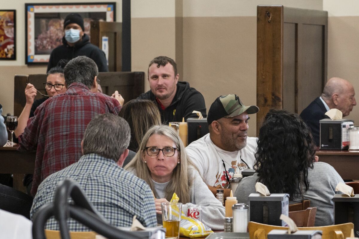 Unmasked people gather inside a Los Angeles restaurant.