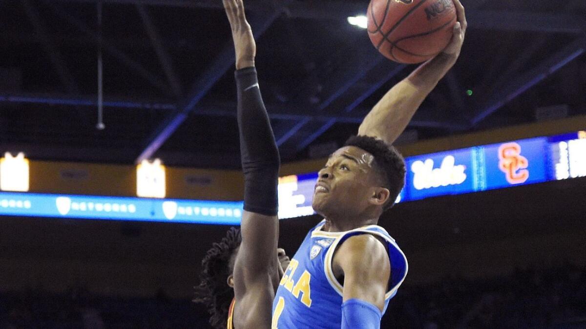 UCLA guard Jaylen Hands, right, goes up for a dunk as USC guard Jonah Mathews defends during the first half on Thursday, Feb. 28.