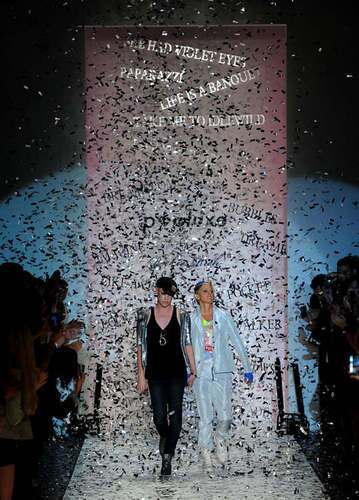 Richie Rich and Ellen DeGeneres enter to a shower of confetti and cheers.
