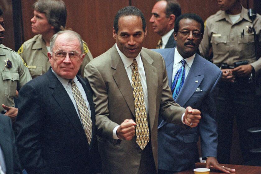 O.J. Simpson reacts in 1995 as he is found not guilty of murdering his ex-wife, Nicole Brown Simpson, and her friend Ronald Goldman. With him are members of his defense team, F. Lee Bailey, left, and Johnnie Cochran Jr.