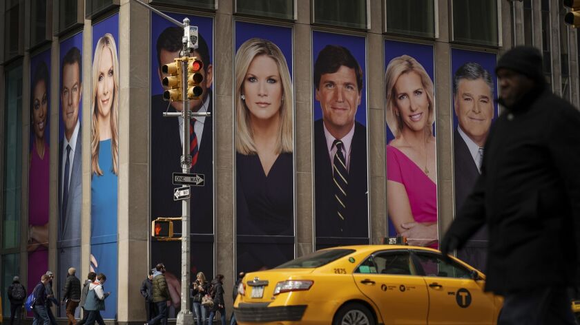 Fox News personalities, including Tucker Carlson, adorn the front of the News Corporation building where the network's sales executives hosted an event for advertisers